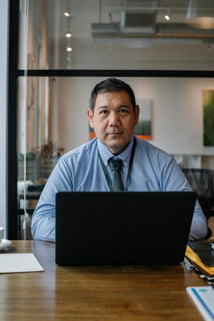 pexels photo 5668886 5668886 Confident ethnic man wearing formal clothes and tie working at netbook while sitting at table in workspace