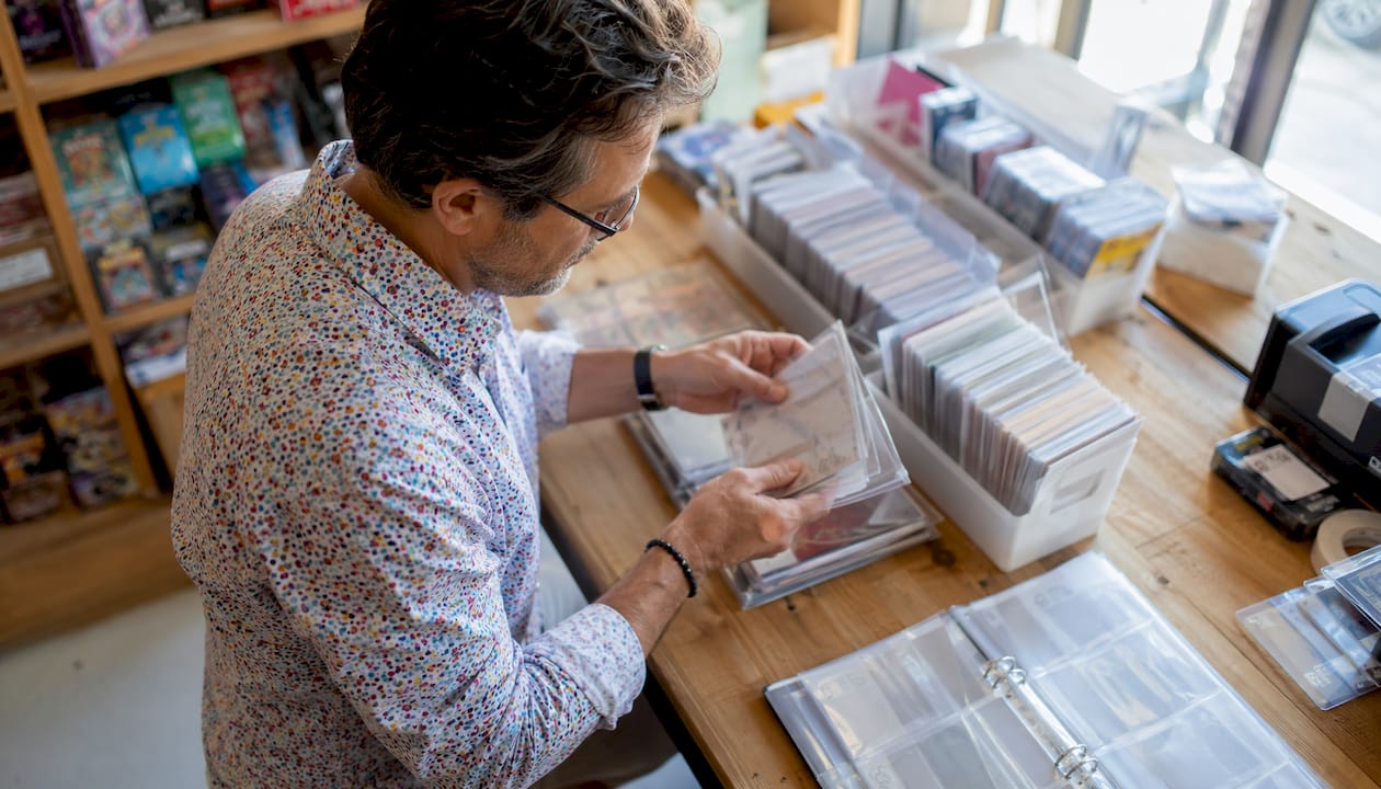Des mains trient soigneusement des pochettes de protection de qualité dans une boutique spécialisée.